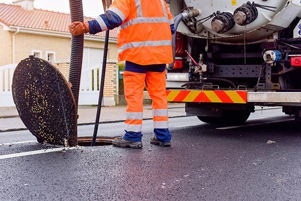 Maintenance worker performing sewer draining