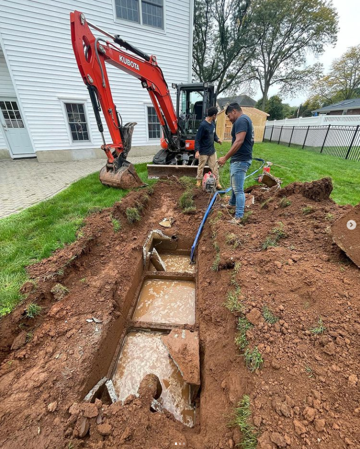 Excavator digging hole for septic tank removal