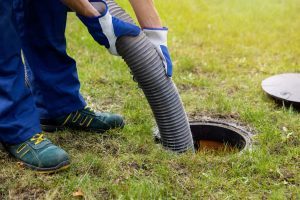 Plumber cleaning out septic tank drain