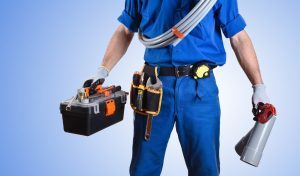 Plumber in uniform with full toolbox and equipment