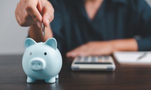 Homeowner putting coin in piggy bank