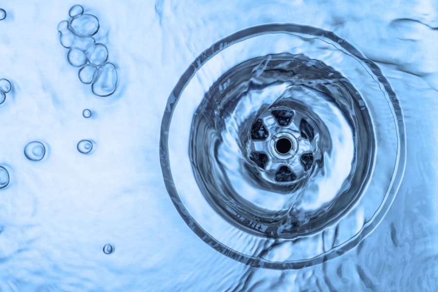 Running water draining into kitchen sink drain