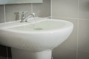 Water overflowing onto floor in bathroom sink