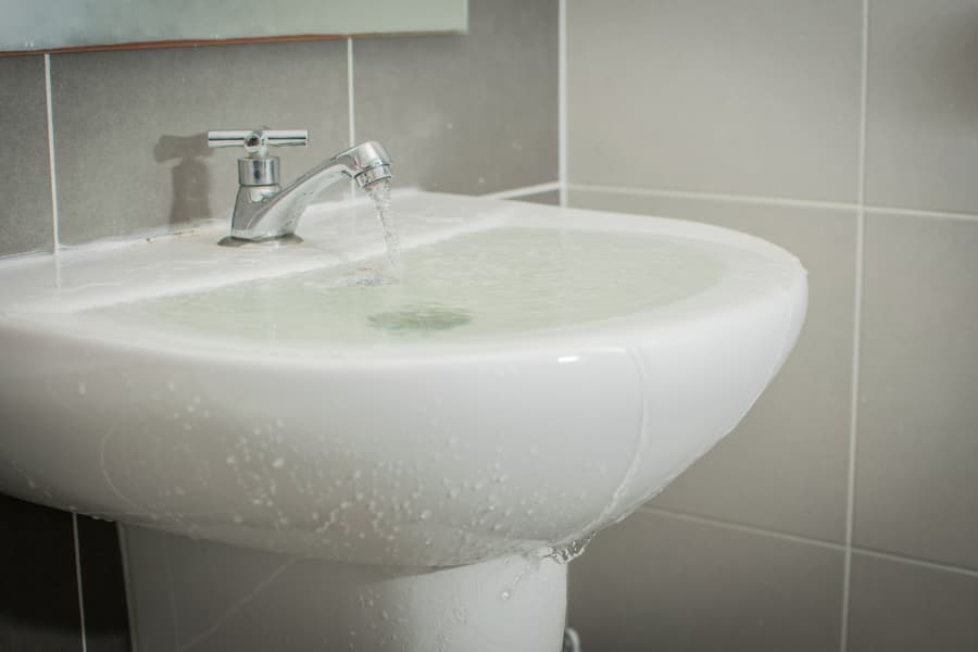 Water overflowing onto floor in bathroom sink