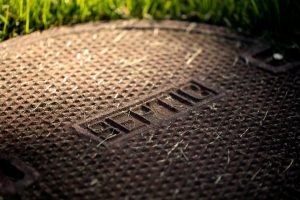 Close up of septic tank manhole cover sitting in grass