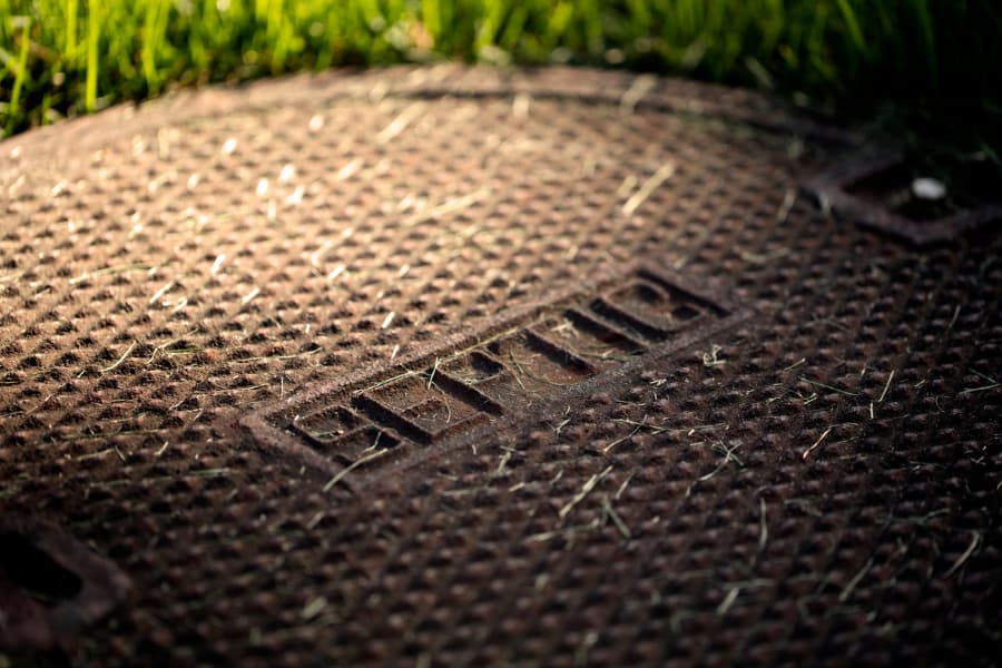 Close up of septic tank manhole cover sitting in grass