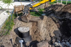 Excavator digging to prepare for septic tank repair