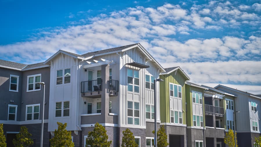 attractive-multicolor-apartment-building-with-cloudy-sky-behind-it