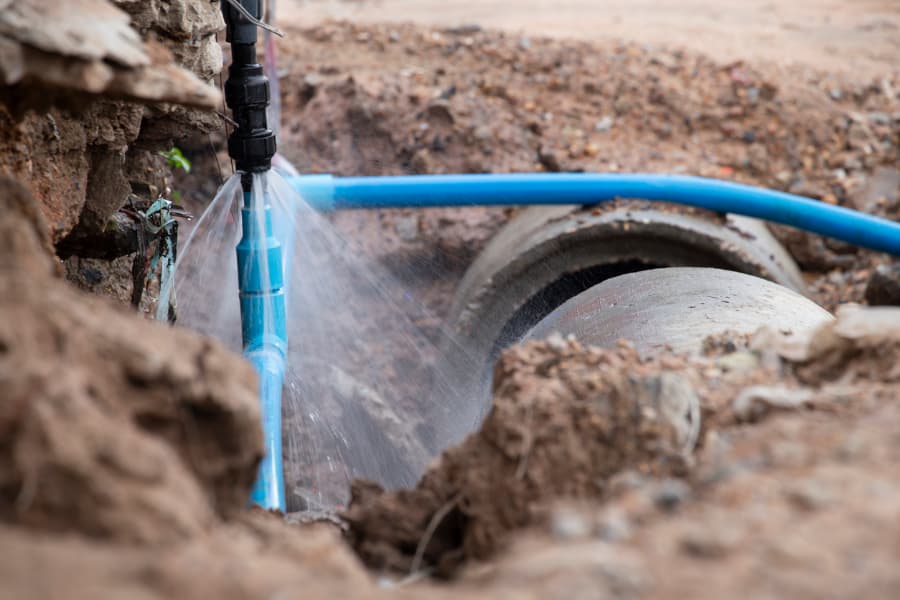 Blue water line burst spraying water