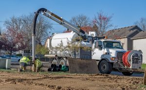 Hydro excavating truck with workers in neighborhood